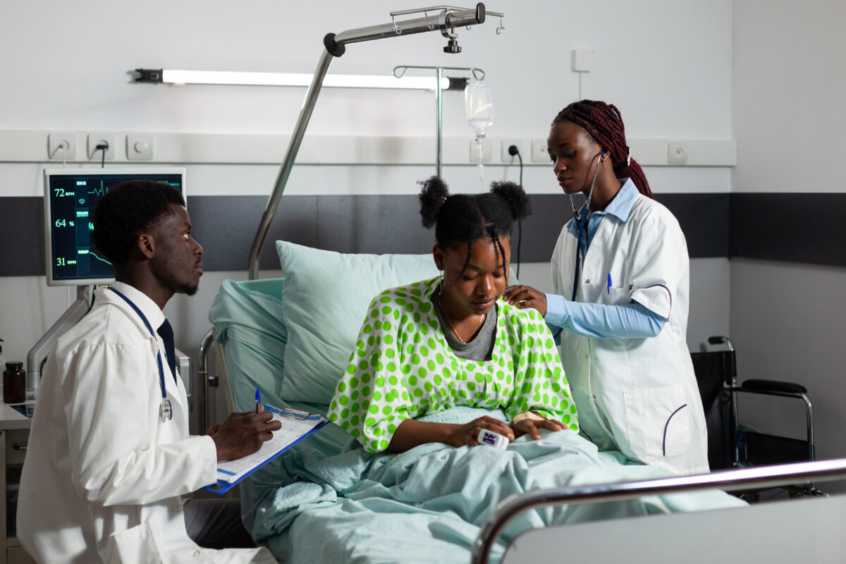 african-american-therapist-doctor-listening-patient-lungs-using-stethoscope-discussing-medical-expertise-with-therapist-sick-young-woman-resting-bed-recovering-after-surgery-hospital-ward-1200x800.jpg